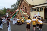 Maypole dancing in front of the Schoolhouse Museum