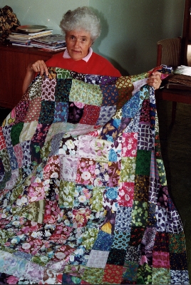Nini Priestely holding the quilt made by her mother 1999