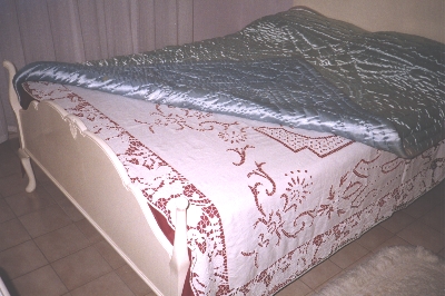 Quilt over traditional cut work bed spread made by Ann Kyranis' mother
