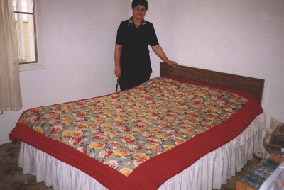 Maria Patounas with her mother's quilt, 2000